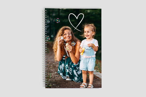 Une mère fait des bulles de savon avec sa fille dans la nature. Toutes deux prennent plaisir à jouer.