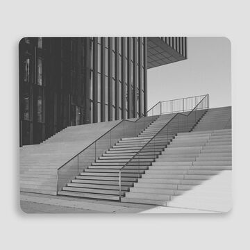 Escalier moderne devant un bâtiment en verre avec des lignes épurées