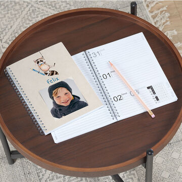 Cahier avec une couverture et une image d'un stylo sur une table.