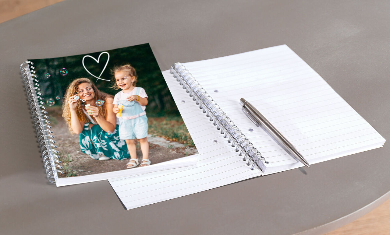 Une femme tient une caméra avec un enfant à ses côtés, visible dans un livre photo.