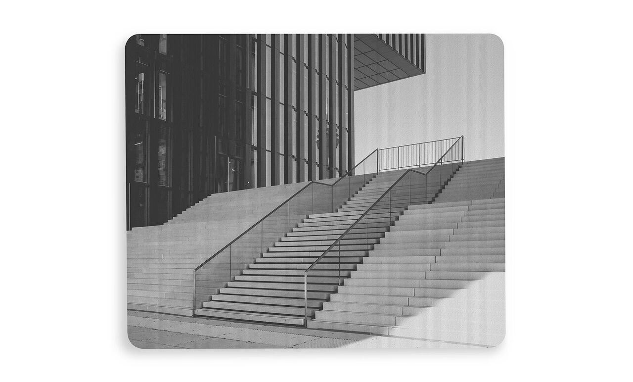 Escalier moderne avec une grille au premier plan d'un bâtiment.