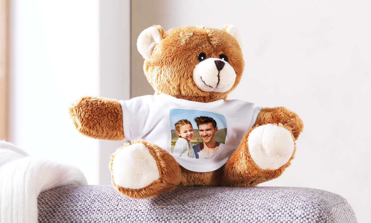 Un ours en peluche douillet avec un T-shirt personnalisé affichant une photo.