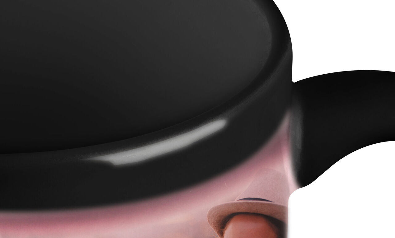 Tasse noir et blanc avec un visage souriant en arrière-plan.