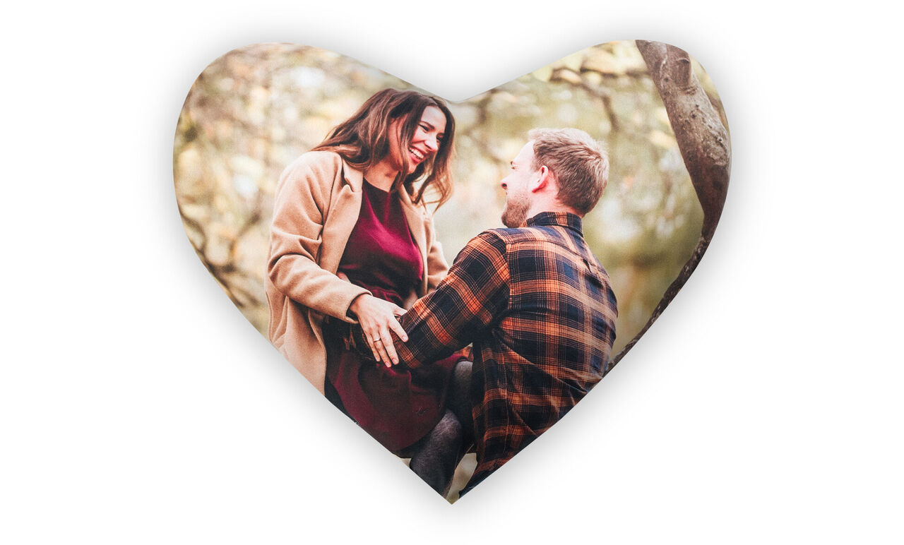 Un couple assis amoureux en plein air, entouré d'arbres, rayonnant de joie et d'affection.