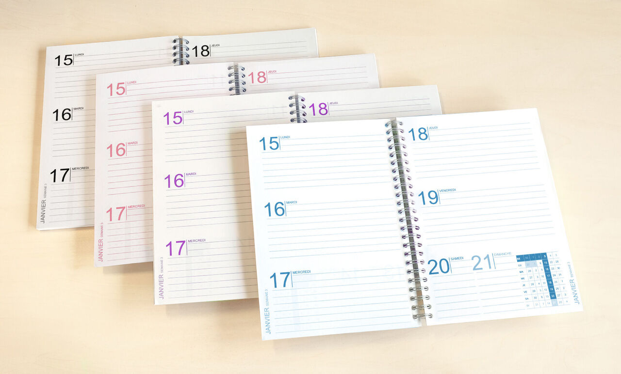 Différents calendriers ouverts avec des pages vides sur une table claire.