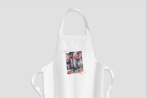 Image montrant deux enfants souriants en tabliers, cuisinant ensemble et s'amusant.