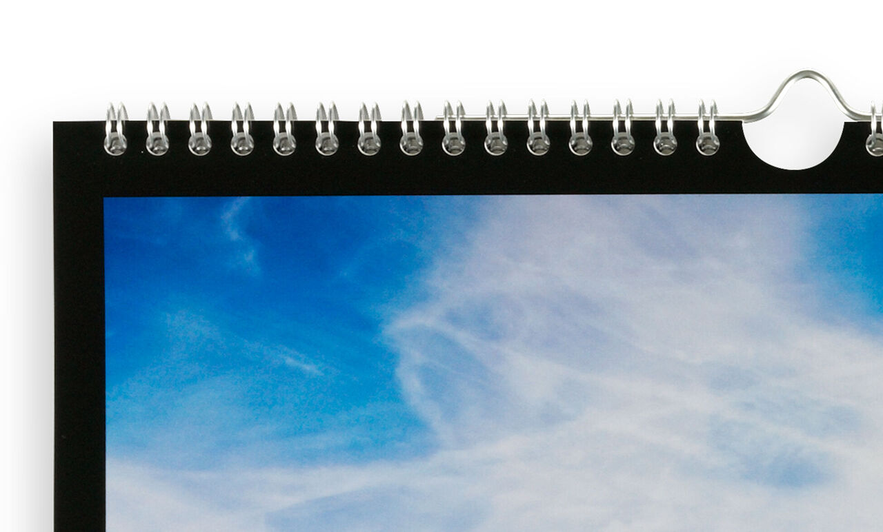 Une partie d'un calendrier mural avec un ciel coloré et des nuages.
