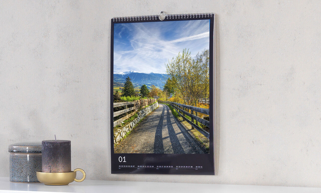 Une image parfaite d'un calendrier suspendu avec un beau paysage. La route traverse arbres et prairies.