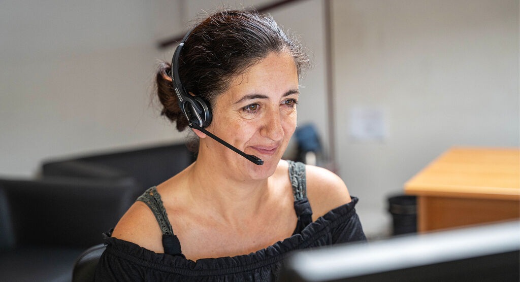 Une personne avec un casque travaille concentrée devant son ordinateur