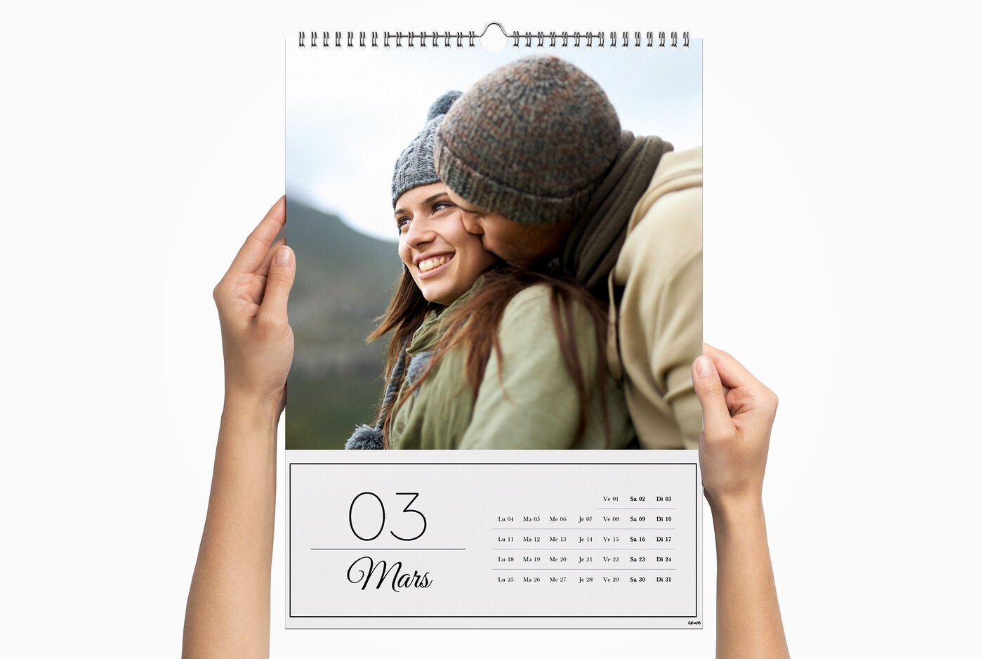 Un grand calendrier personnalisé entre les mains d'une personne, avec la photo d'un couple s'embrassant