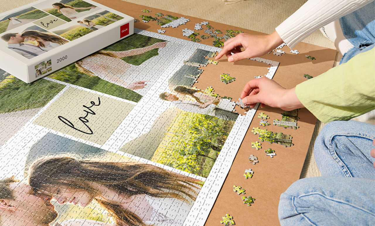 Deux personnes assemblent un puzzle personnalisé avec des photos et le mot « love »