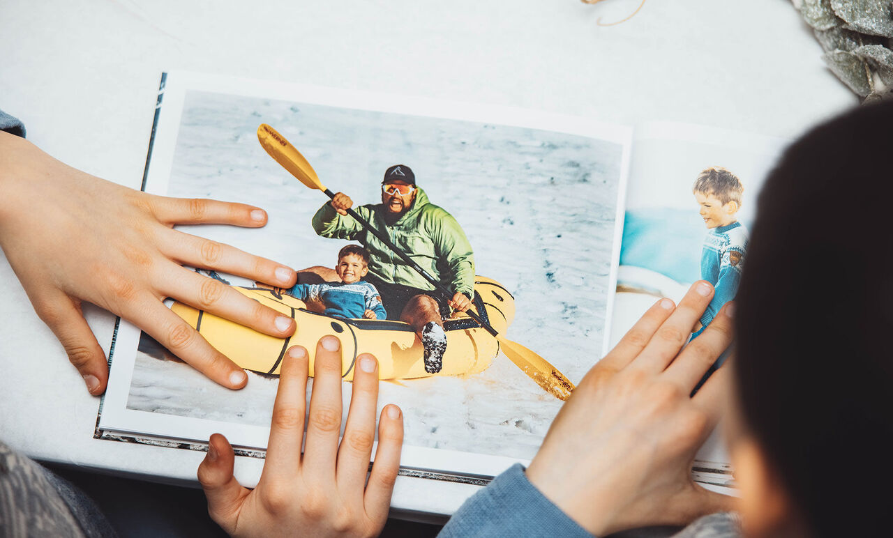 Un enfant et un adulte pagaient joyeusement dans un kayak jaune dans un livre photo.