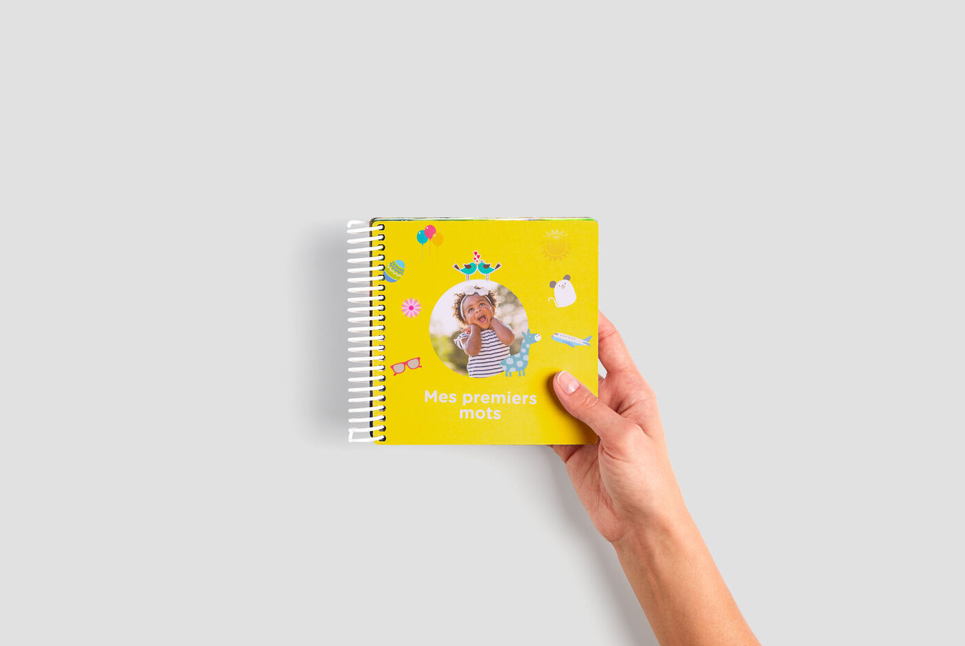 Un livre photo cartonné pour bébé de 14x14 cm avec en couverture une photo d'un enfant et écrit dessus Mes premiers mots