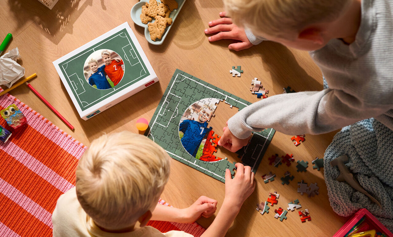 Deux enfants assemblent un puzzle personnalisé thème foot