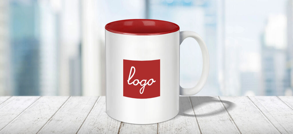 Tasse blanche avec couvercle rouge et logo sur une table
