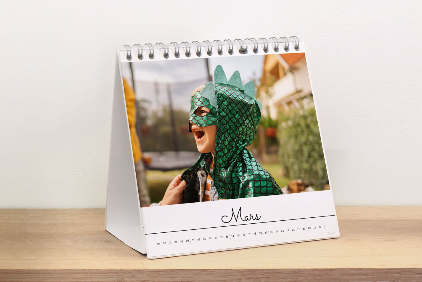 Un calendrier à anneaux montrant un enfant en costume de dragon souriant joyeusement