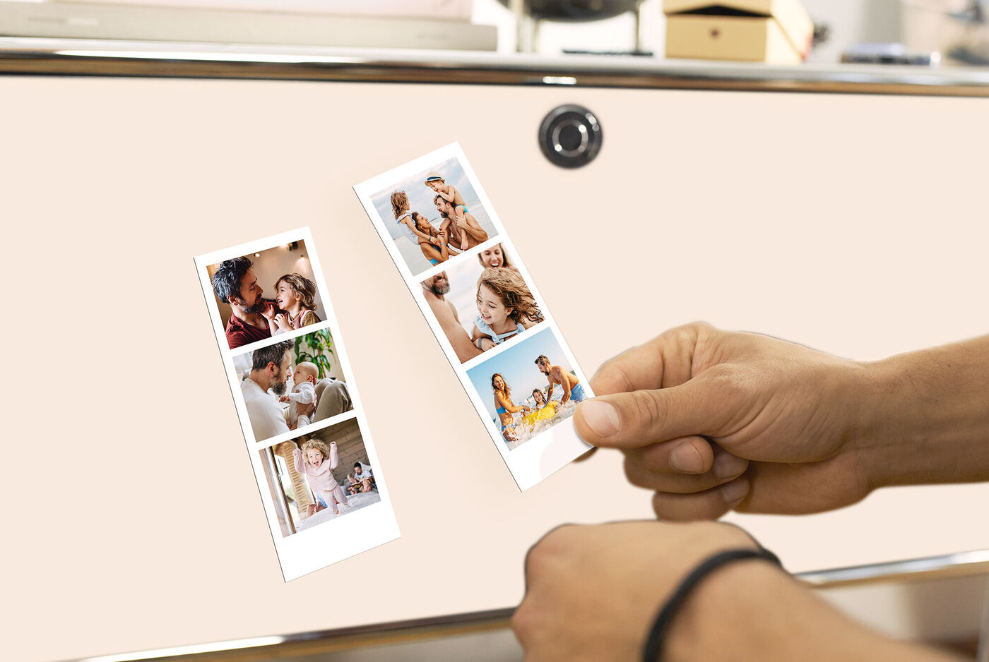 Main tient deux photos encadrées de moments heureux, comme famille et amitié, sur une table.