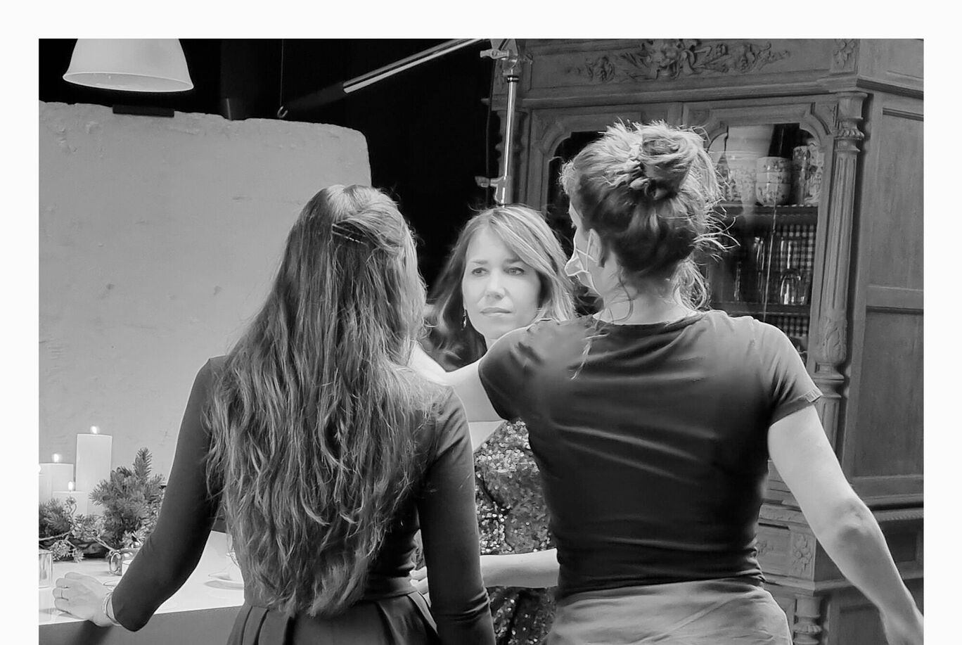 Trois femmes s'enlacent autour d'une table joliment dressée.