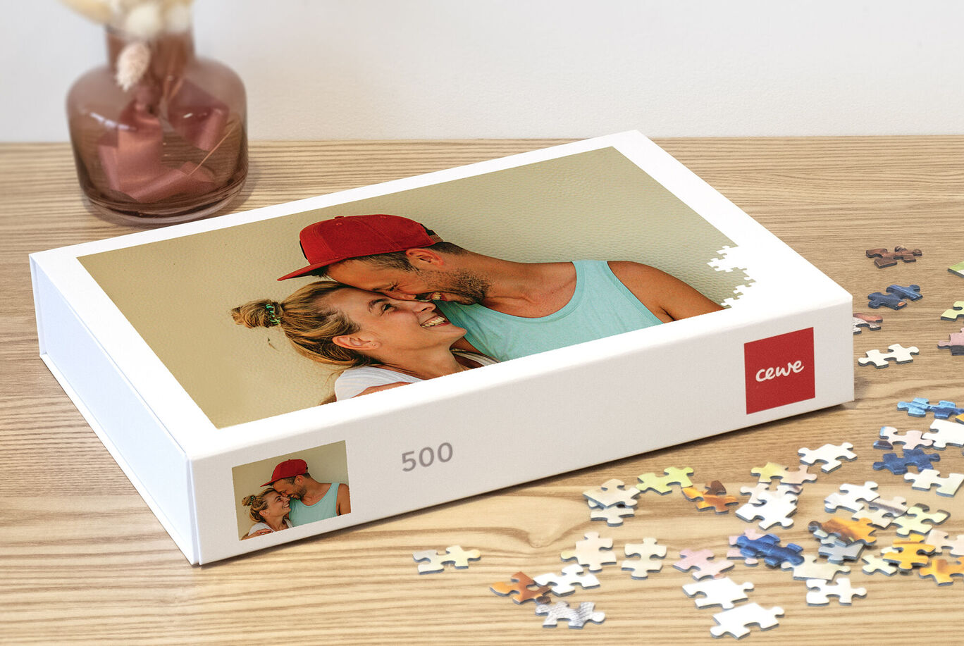 Boîte de puzzles avec une photo d'un couple et des pièces de puzzle colorées sur une table