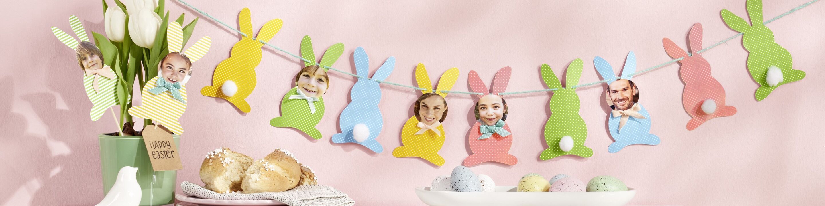 Décoration de Pâques avec guirlande de lapins colorés, fleurs printanières et œufs décoratifs