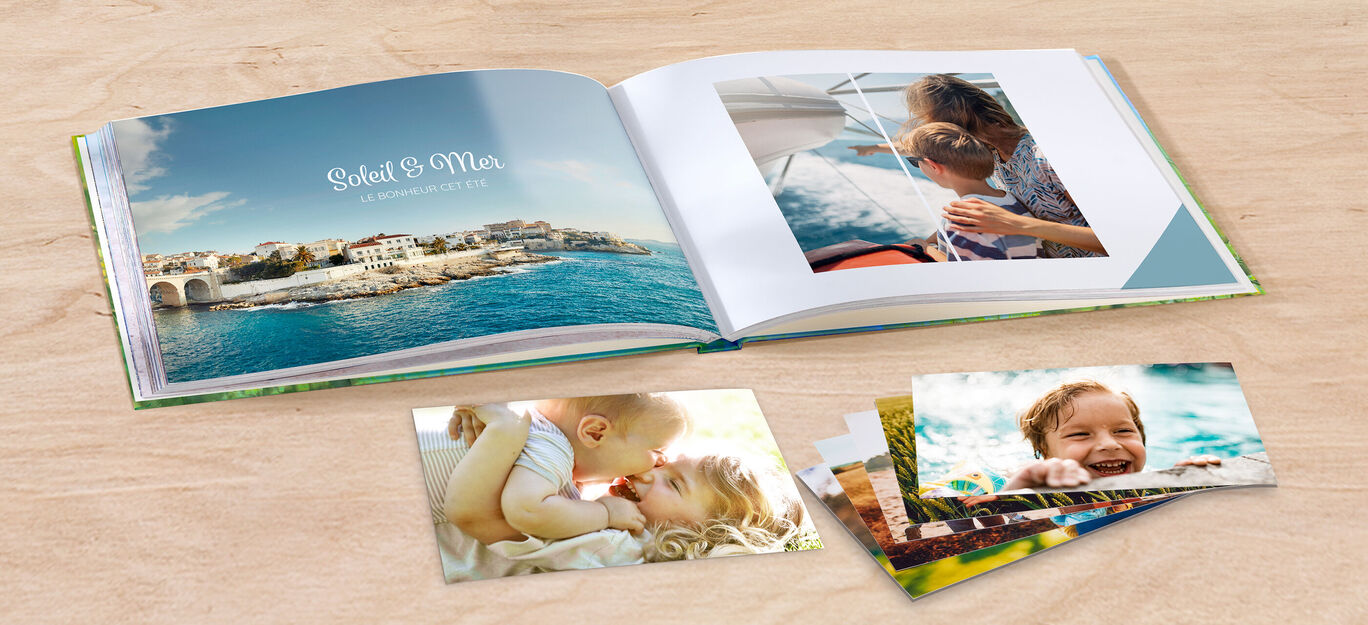 Un album CEWE ouvert avec une image de la mer et une référence aux moments de voyage. Des tirages photo à côté.