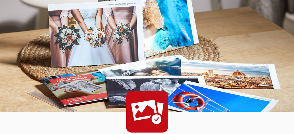 Divers produits photo CEWE sont disposés sur une table, y compris des cartes et des photos de vacances.