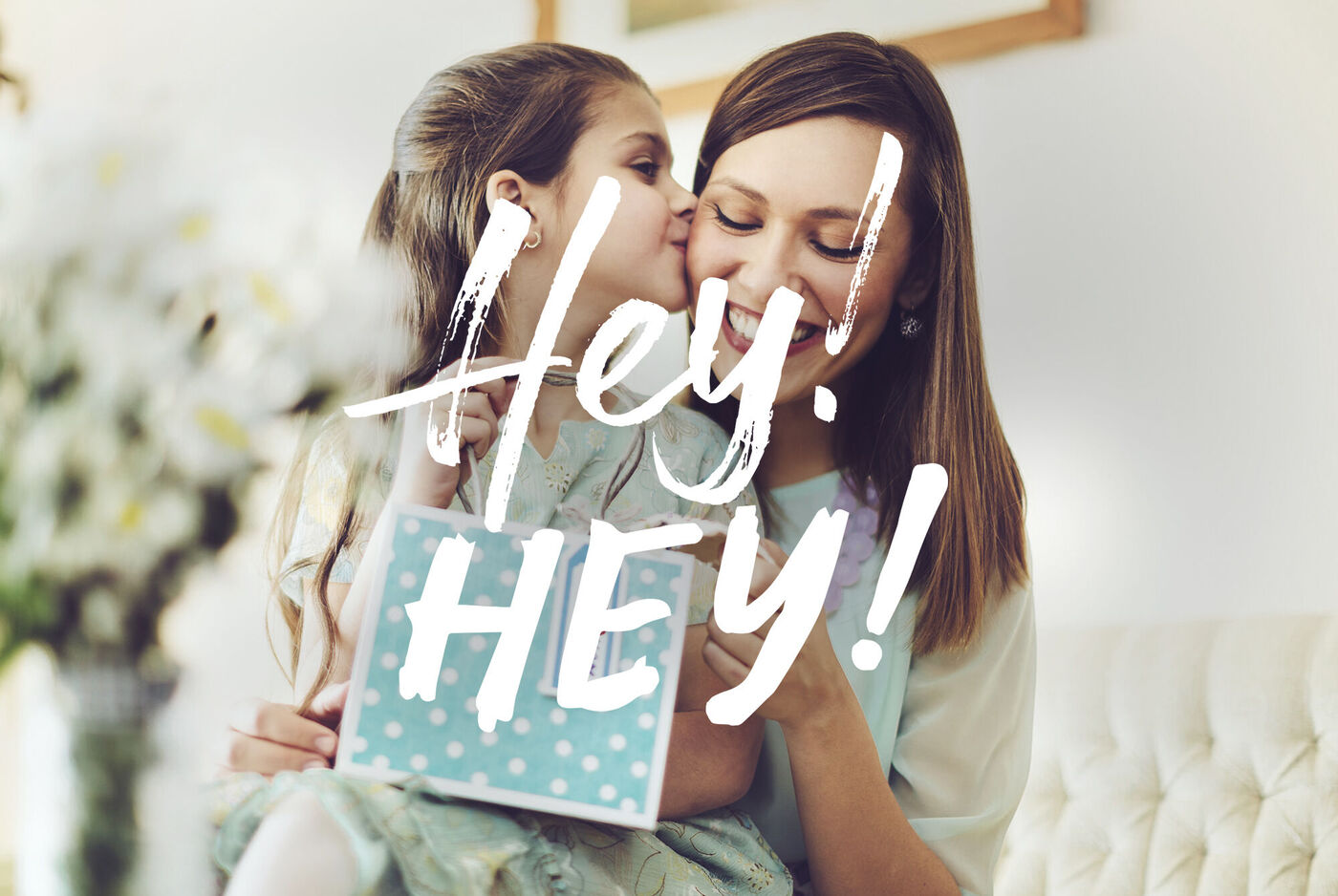 Deux amies partagent un moment joyeux en souriant. L'une tient un cadeau créatif à pois.