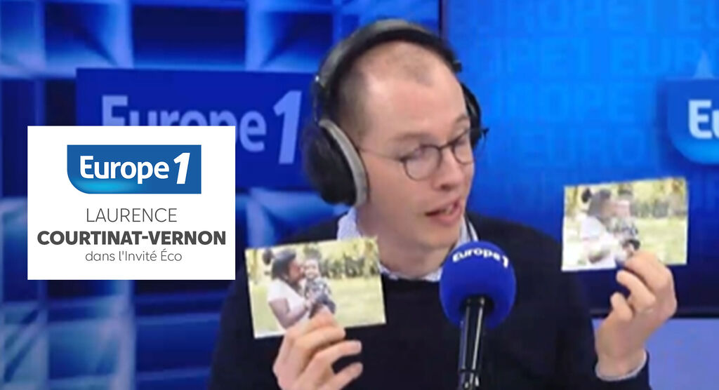 Un homme tient deux photos et parle avec un microphone devant un fond bleu
