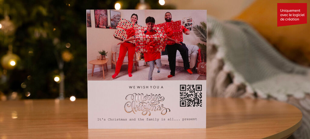 Une famille pose joyeusement devant un sapin de Noël en tenant des cadeaux