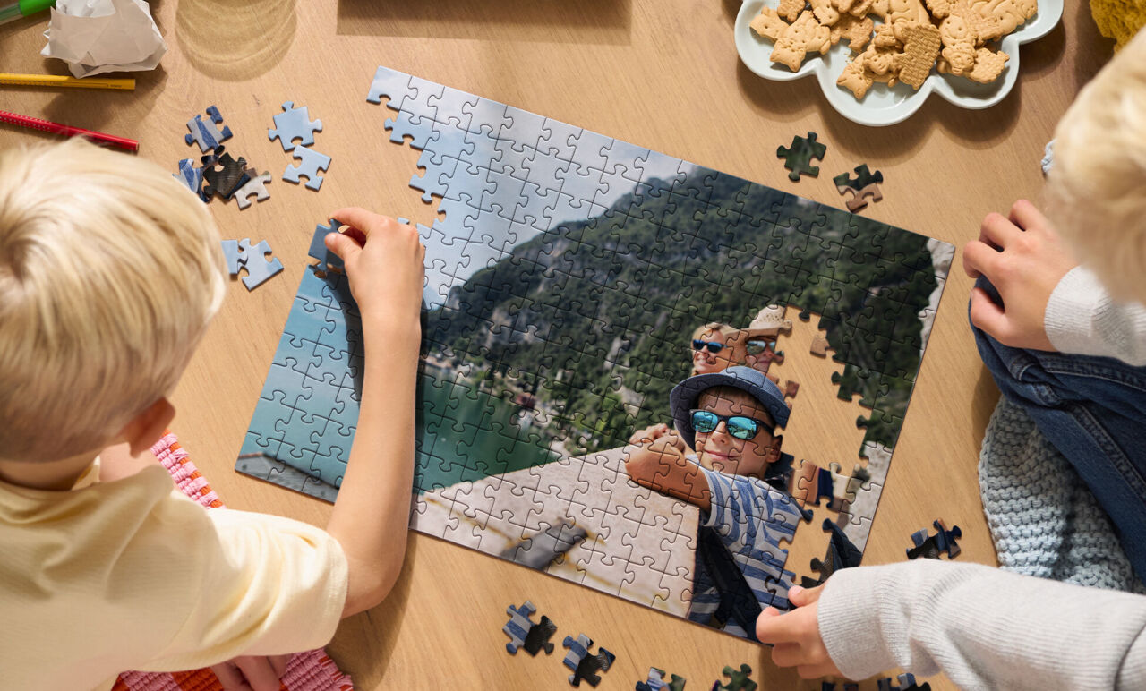2 enfants assemblent un puzzle personnalisé de voyage en montagne