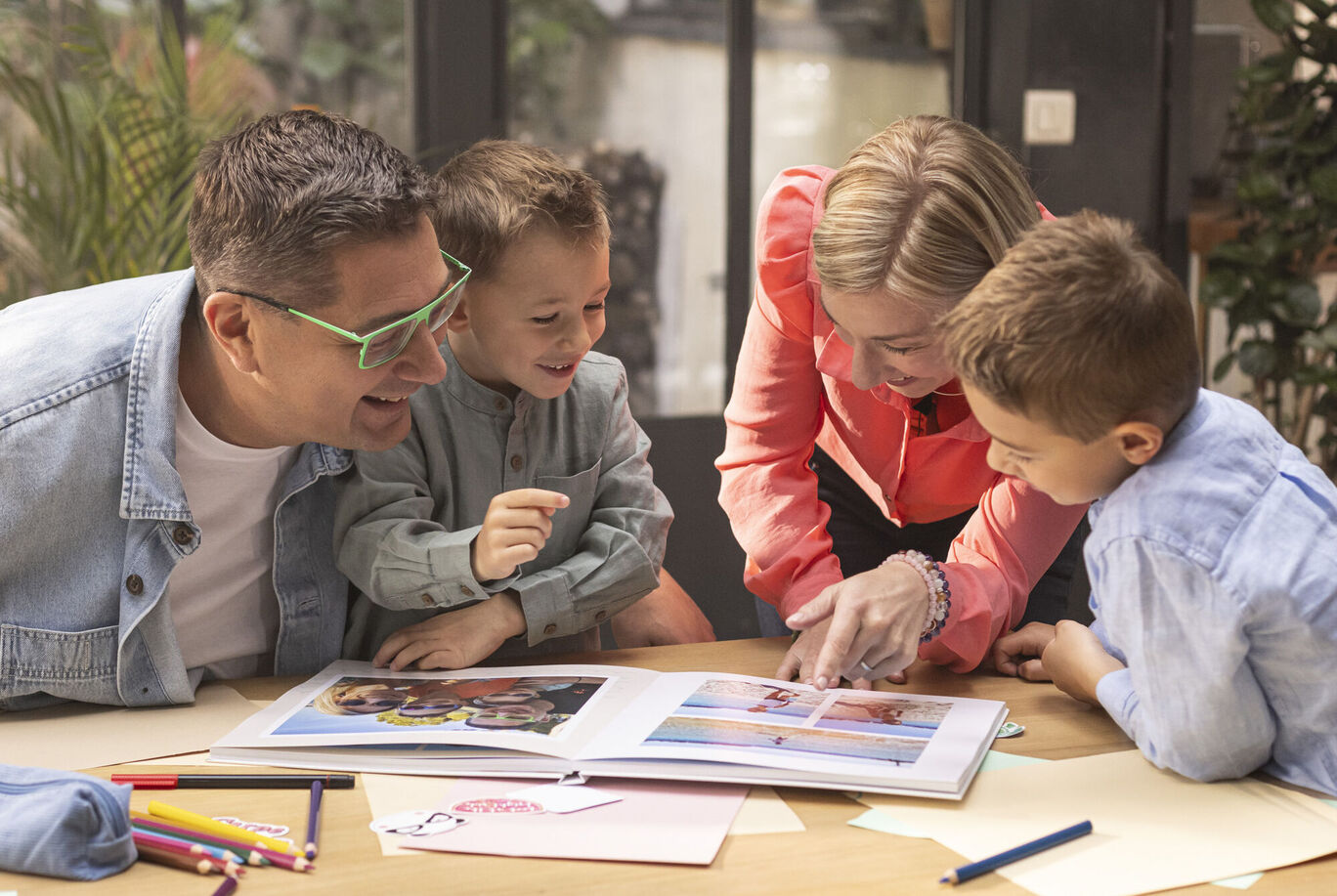 Une famille feuilletant ensemble un album photo montrant des souvenirs.