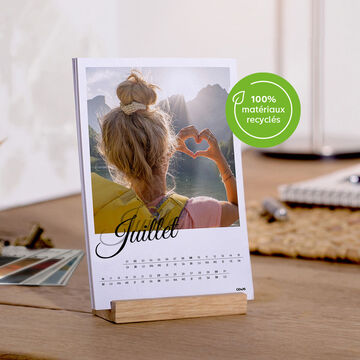 Page de calendrier montrant une fille formant un cœur avec les mains et les montagnes en arrière-plan