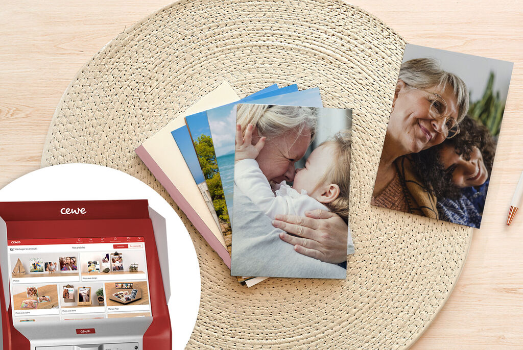 Diverses cartes CEWE sont posées sur une table ronde, à côté d'un livre photo créatif CEWE.