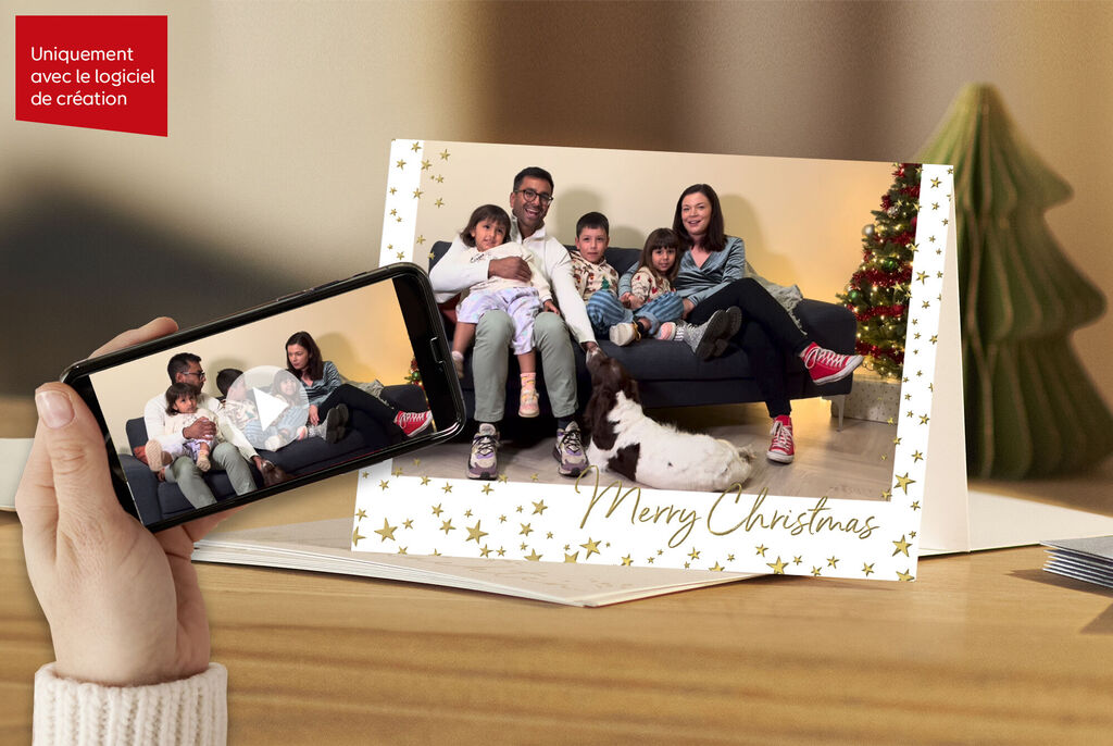 Une famille est assise ensemble sur le canapé, un sapin de Noël en arrière-plan, contente avec les cartes CEWE.