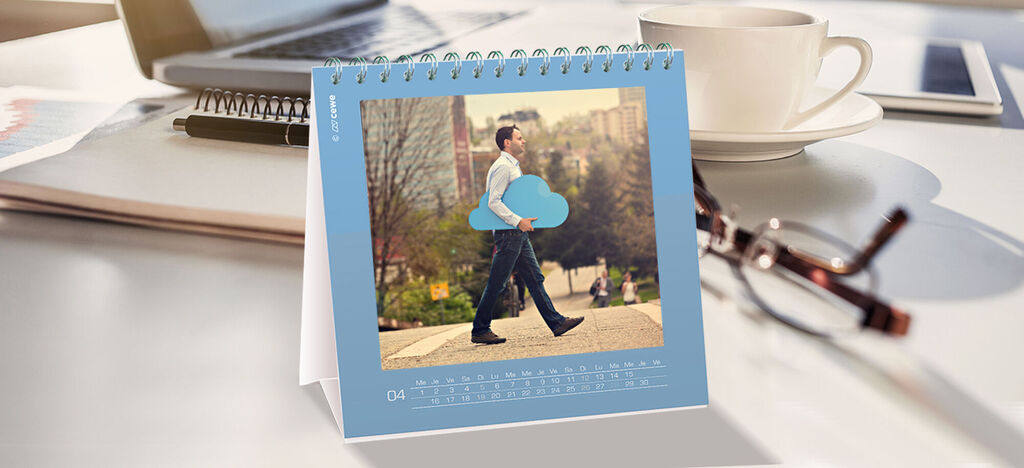 Un homme porte un grand calendrier nuage bleu et se promène dans un parc.