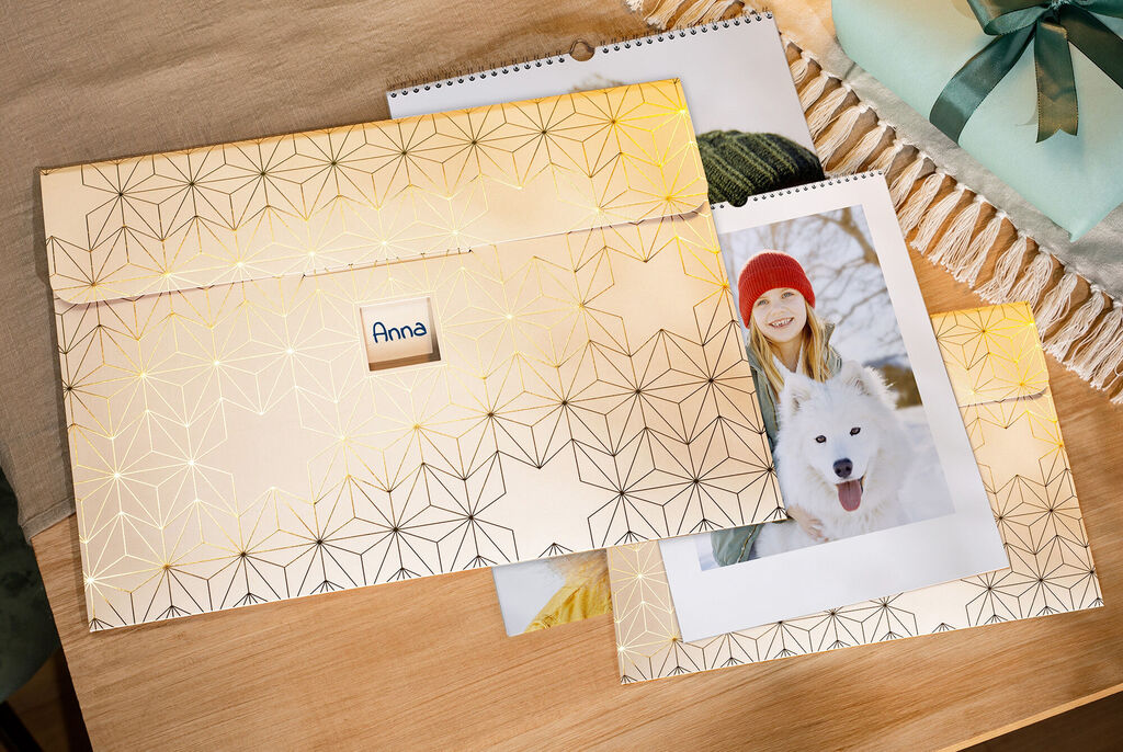 Élégantes boîtes cadeaux dorées avec photos et inscription "Anna" dessus.