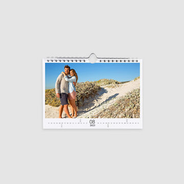 Un couple heureux s'embrasse sur la plage dans un calendrier.