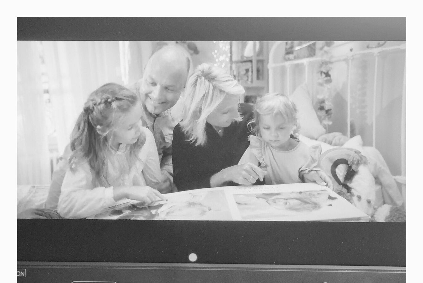 Une famille regarde ensemble un livre photo et partage des souvenirs.