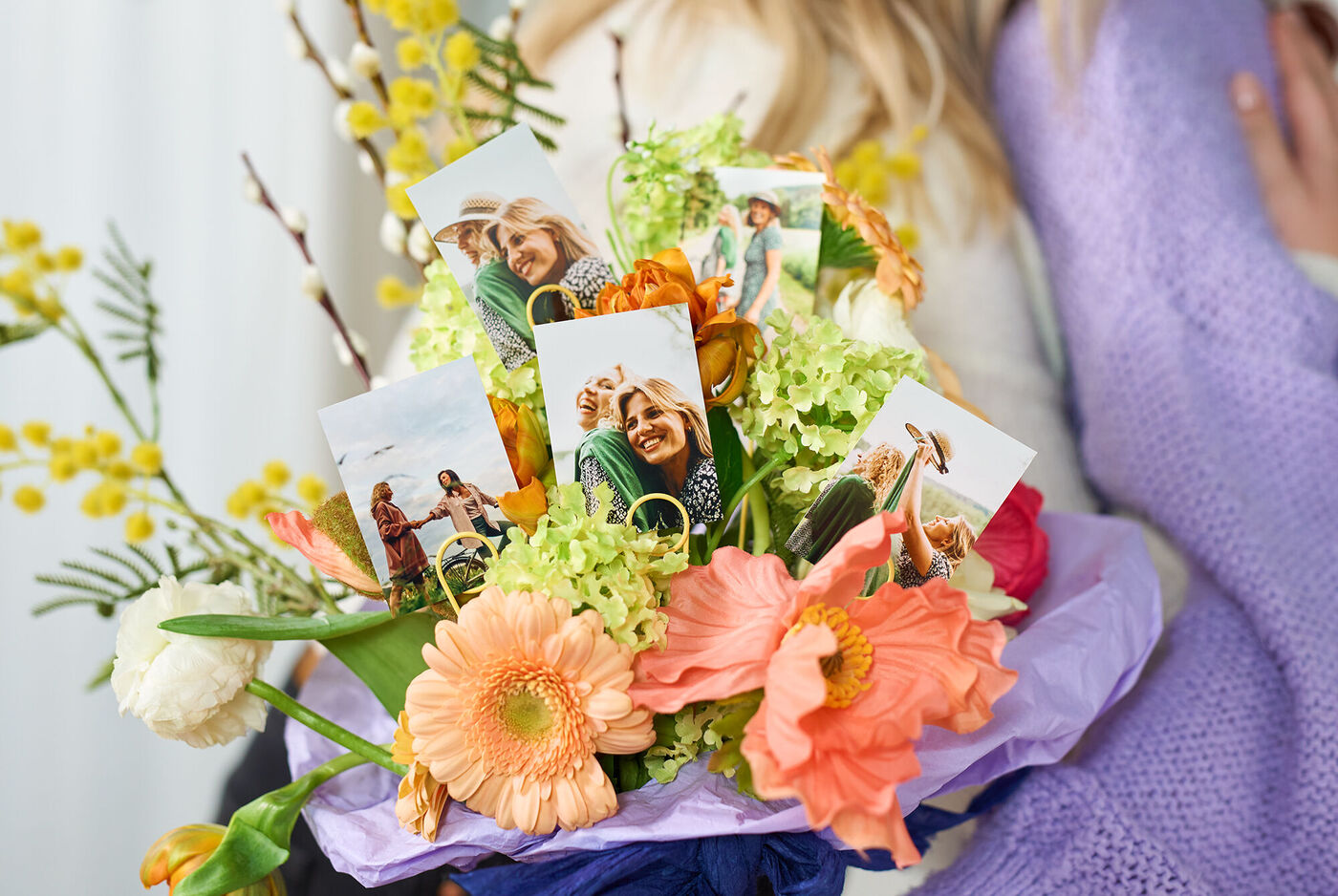 Tirages photo personnalisés glissés dans un bouquet de fleurs coloré