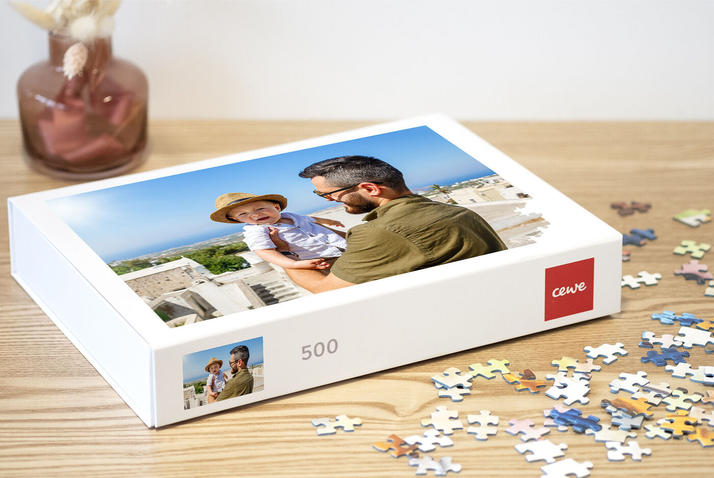 Boîte de puzzle avec une photo touchante d'un père et son enfant, entourés de pièces de puzzle colorées.