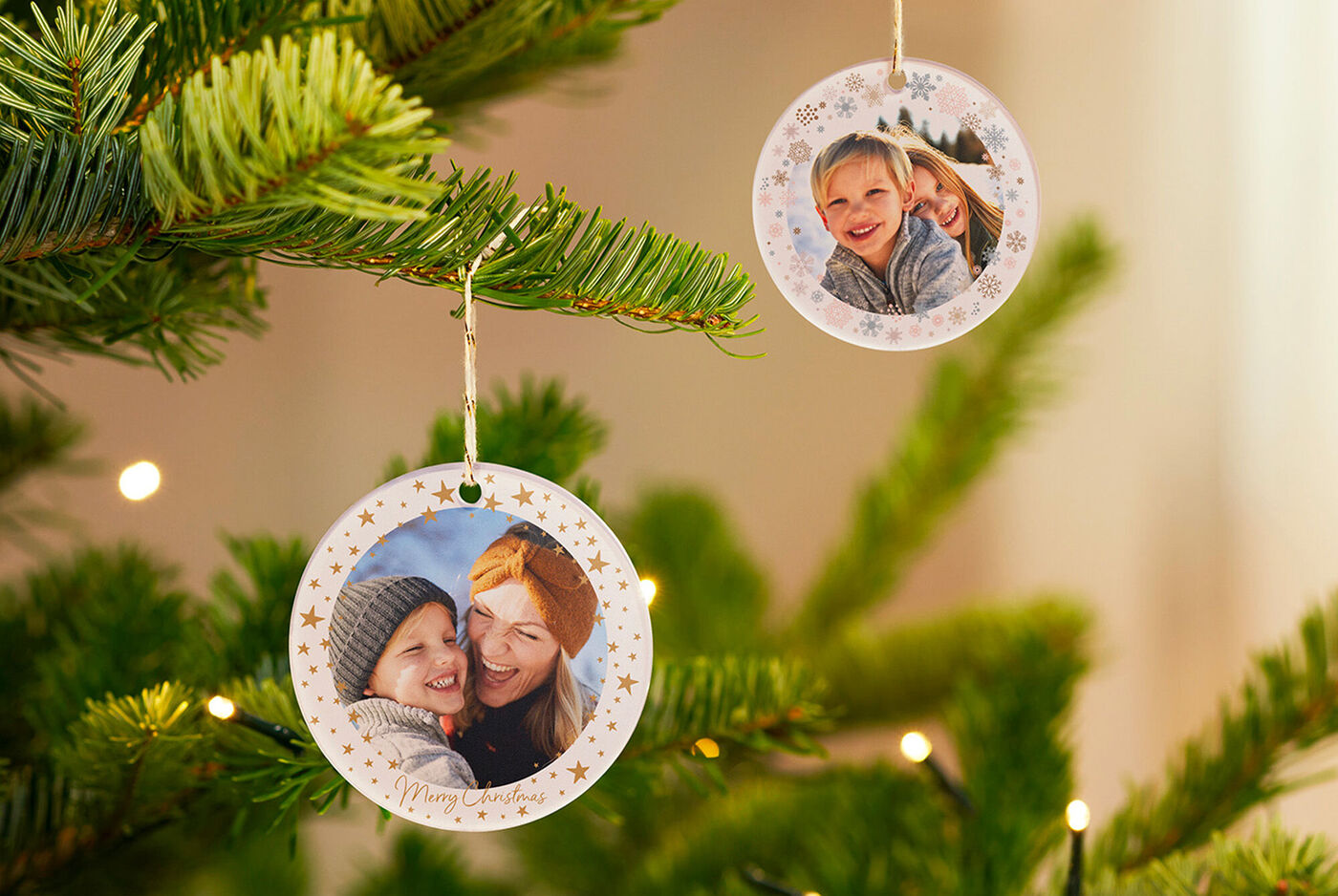 Deux ornements de Noël en papier photo pendent à un sapin vert