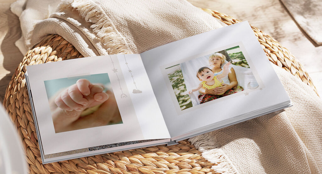 Un livre photo ouvert avec des souvenirs et un adorable pied de bébé.