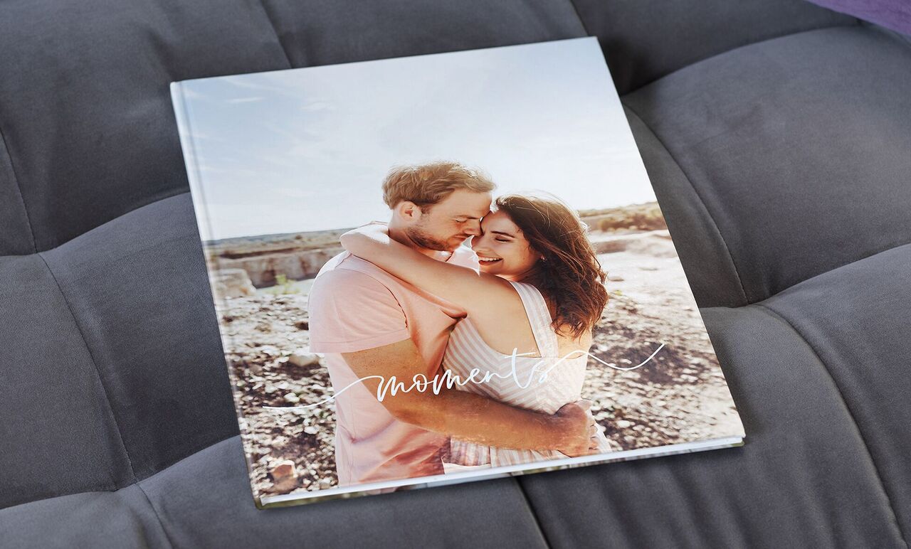 Un album photo affectueux intitulé 'Moments', montrant une étreinte. Il transmet le sentiment de proximité et de souvenirs spéciaux.
