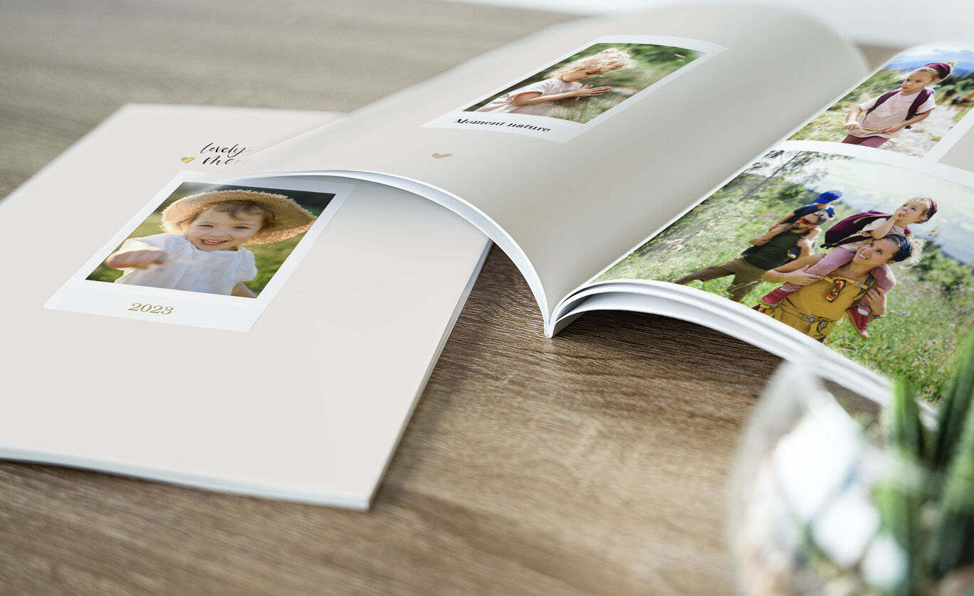 Un album photo CEWE ouvert avec des images d'enfants heureux dans la nature