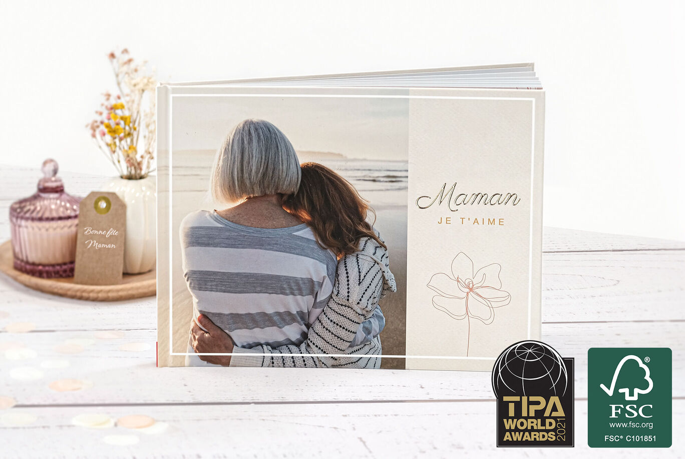 Des personnes s'enlacent chaleureusement près d'un album photo sur la plage