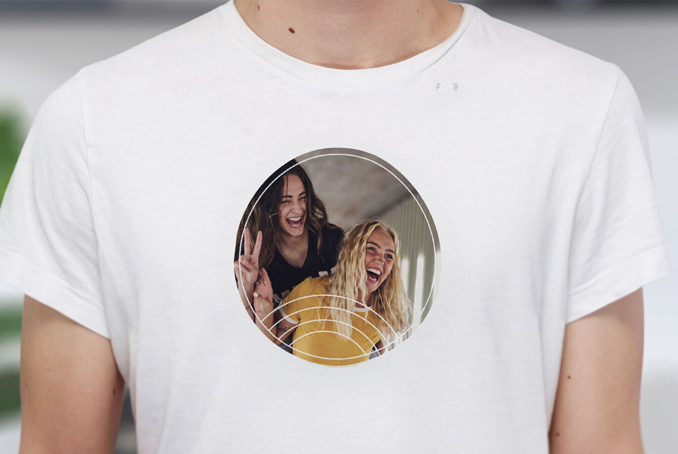 Deux amis sourient dans une image ronde sur un T-shirt.