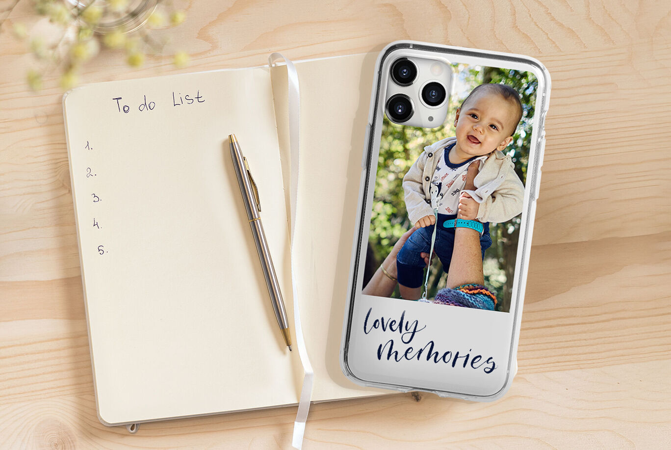 Un smartphone personnalisé avec une photo et le texte 'souvenirs mignons' sur une table en bois.