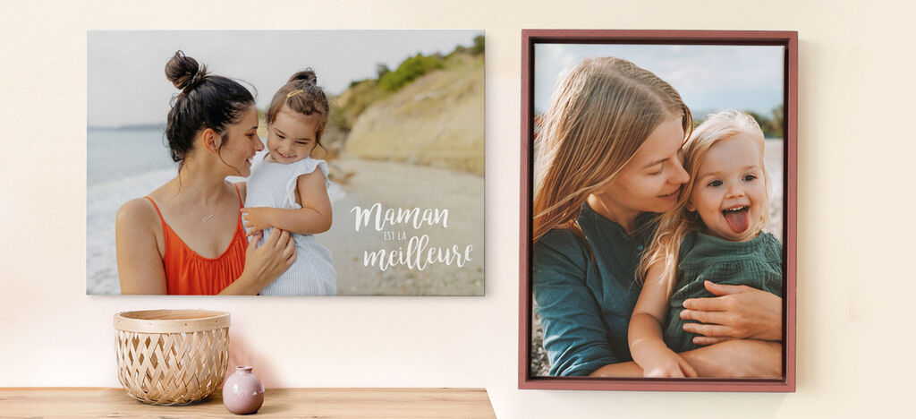 Une mère prend son enfant dans ses bras sur la plage. En arrière-plan, un paysage côtier.