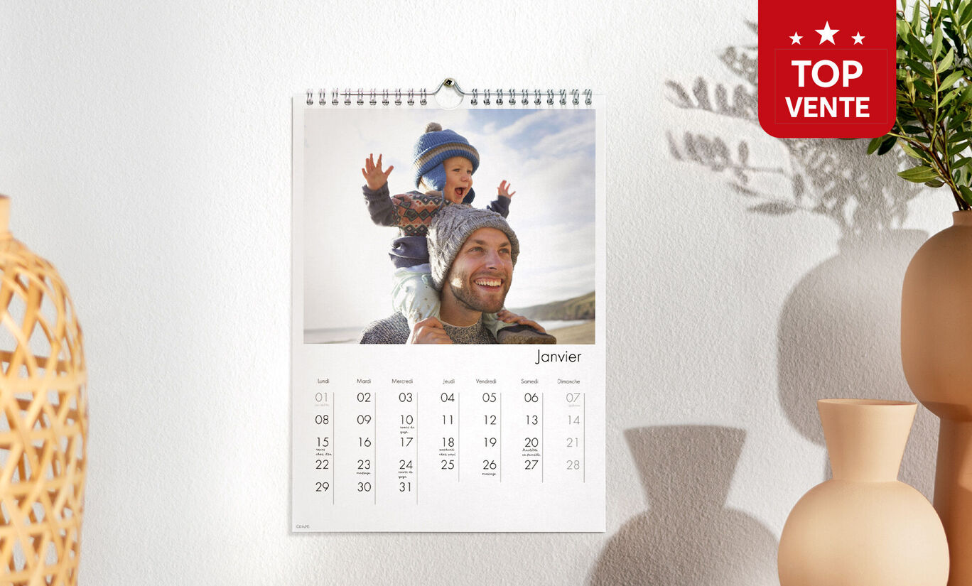 Un calendrier photo A4 portrait accroché au mur avec la photo d'un enfant sur les épaules de son papa
