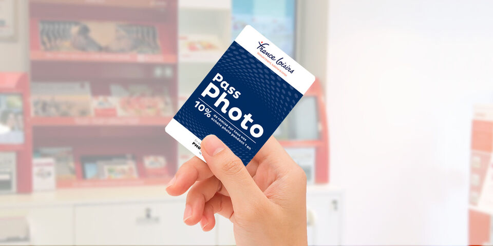 Une main tient une carte photo avec une remise de 10% d'un fournisseur de services photo.